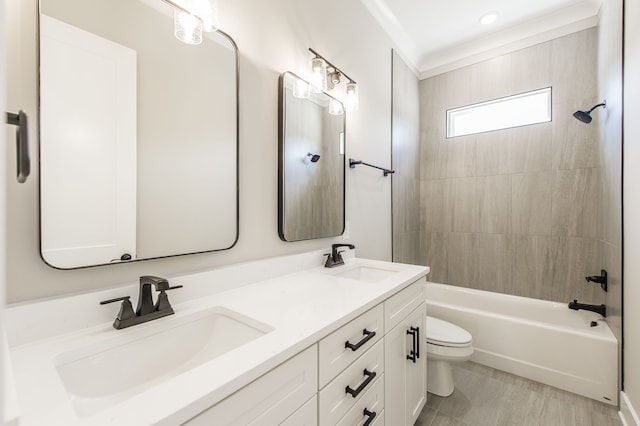 full bathroom featuring vanity, crown molding, tiled shower / bath, and toilet