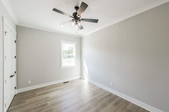 unfurnished room featuring ceiling fan, wood-type flooring, and crown molding