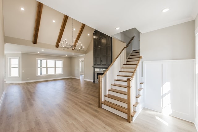 interior space with beam ceiling, light hardwood / wood-style flooring, high vaulted ceiling, crown molding, and a chandelier