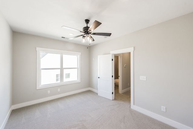 empty room featuring ceiling fan and light carpet