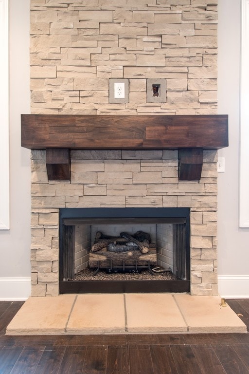 interior details featuring hardwood / wood-style flooring and a stone fireplace