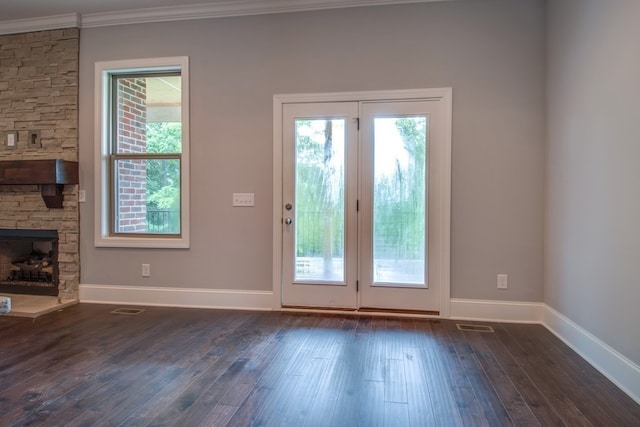 doorway featuring a fireplace, crown molding, and dark hardwood / wood-style flooring