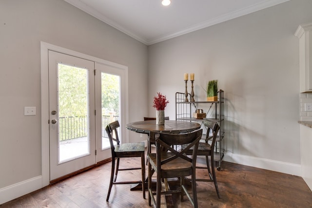 dining space with hardwood / wood-style flooring and crown molding