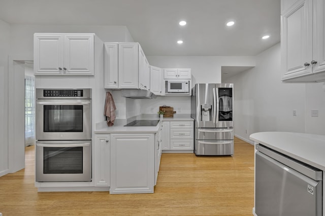 kitchen with white cabinets, light wood-type flooring, and appliances with stainless steel finishes