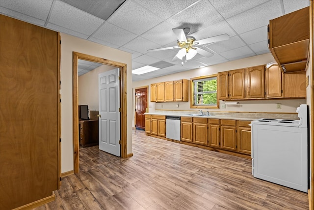 kitchen with a drop ceiling, dishwasher, stove, sink, and light hardwood / wood-style floors