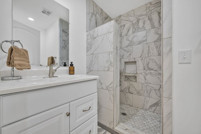 bathroom featuring vanity and tiled shower