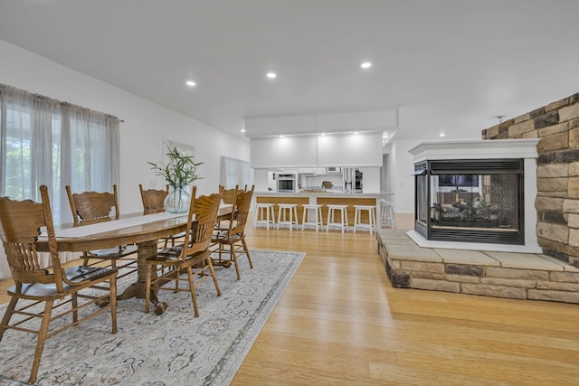 dining area with a fireplace and light hardwood / wood-style flooring