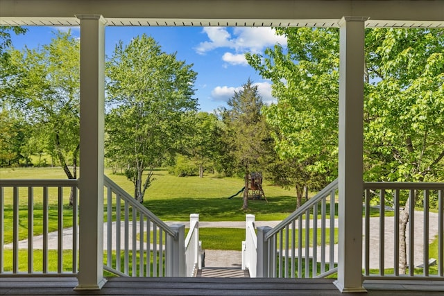 wooden deck featuring a yard and a playground