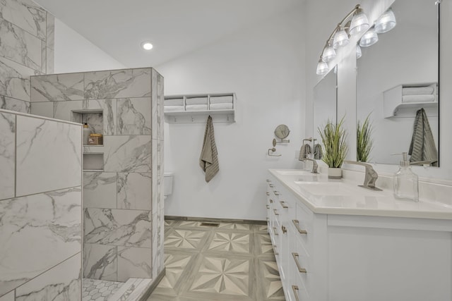 bathroom with vanity, tiled shower, and vaulted ceiling