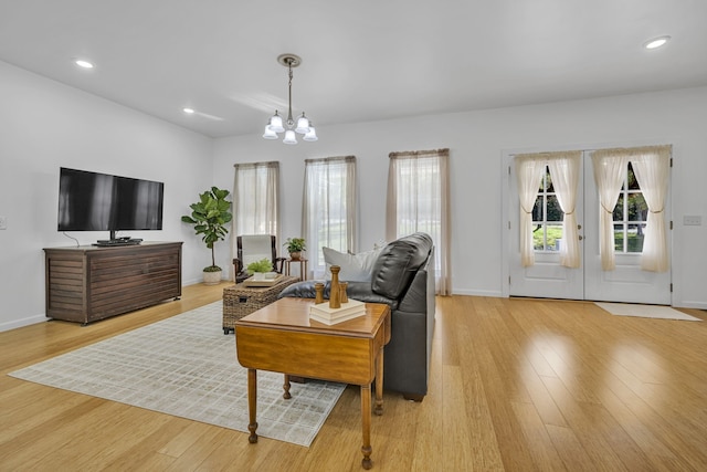 living room with a notable chandelier and light hardwood / wood-style floors