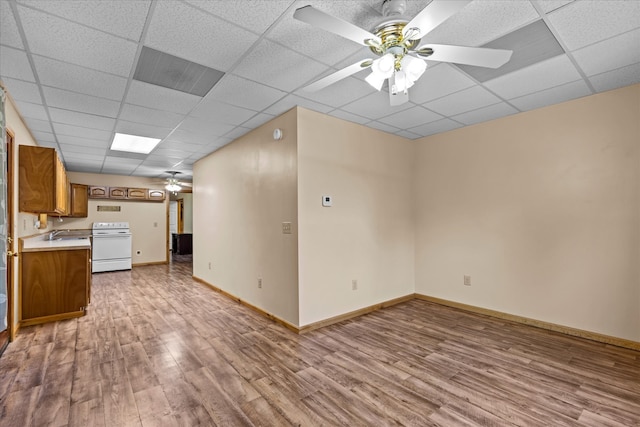 unfurnished living room featuring a paneled ceiling, light hardwood / wood-style flooring, and ceiling fan