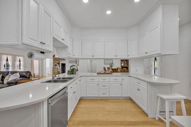 kitchen featuring a kitchen bar, kitchen peninsula, white cabinets, and stainless steel dishwasher