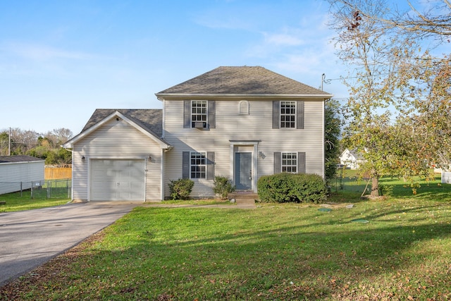 colonial-style house featuring a garage and a front lawn