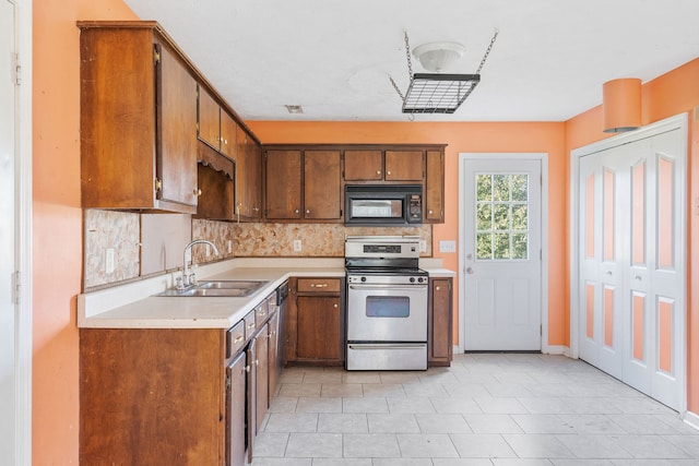 kitchen with stainless steel range, backsplash, and sink