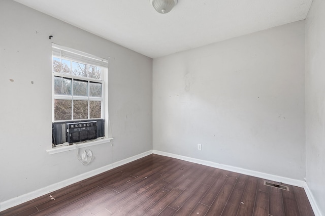 empty room featuring cooling unit and dark hardwood / wood-style floors