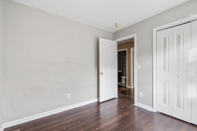 unfurnished bedroom featuring dark wood-type flooring and a closet