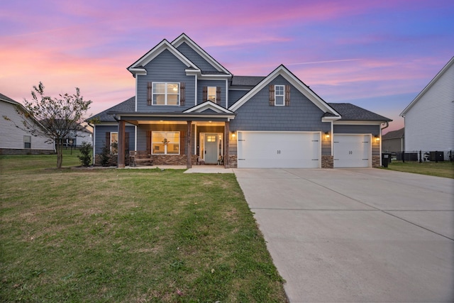 craftsman house featuring a lawn, a porch, and a garage