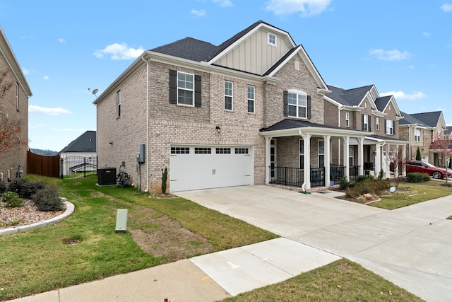 view of front of home with a front yard, a garage, a porch, and central AC unit