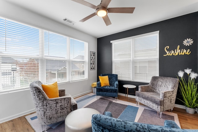 living area with ceiling fan and wood-type flooring