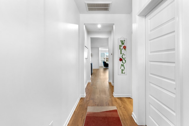 corridor with light hardwood / wood-style flooring