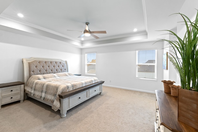 bedroom featuring a raised ceiling, ceiling fan, light carpet, and crown molding