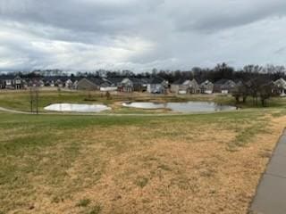 surrounding community with a lawn and a water view