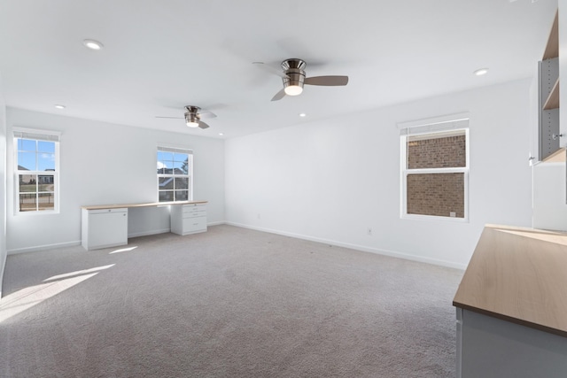 unfurnished living room featuring ceiling fan and light colored carpet