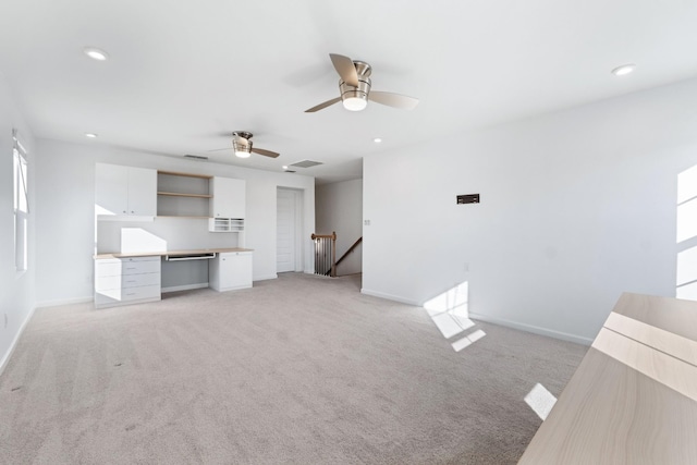 unfurnished living room with ceiling fan and light colored carpet