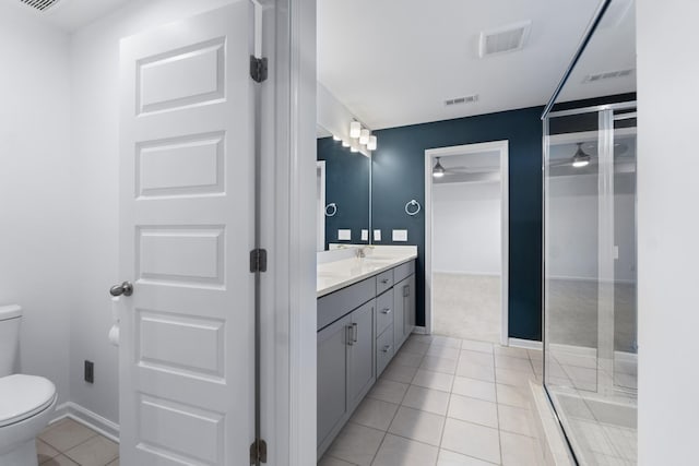 bathroom featuring tile patterned floors, vanity, a shower, toilet, and ceiling fan