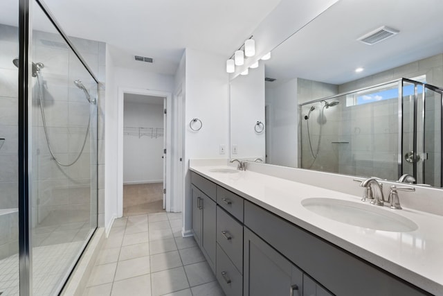 bathroom featuring a shower with shower door, tile patterned floors, and vanity