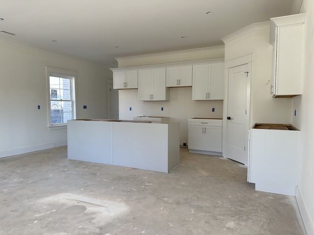 kitchen featuring crown molding, white cabinets, and a kitchen island