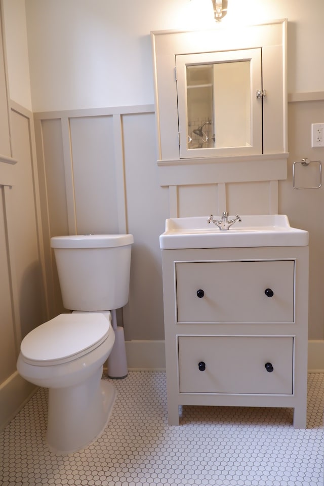 bathroom featuring tile patterned flooring, vanity, and toilet