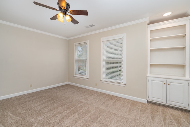 carpeted empty room with ceiling fan and ornamental molding