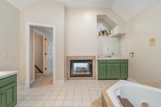 bathroom featuring tiled tub, a fireplace, vanity, and lofted ceiling