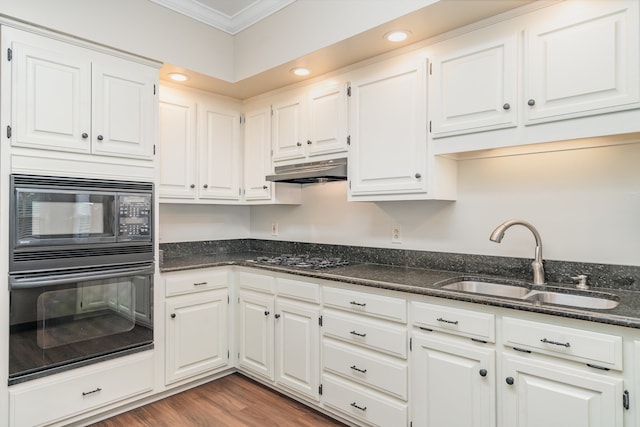 kitchen featuring ornamental molding, sink, black appliances, dark stone countertops, and white cabinetry