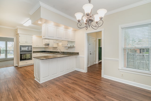 kitchen featuring kitchen peninsula, decorative light fixtures, white cabinets, and black appliances