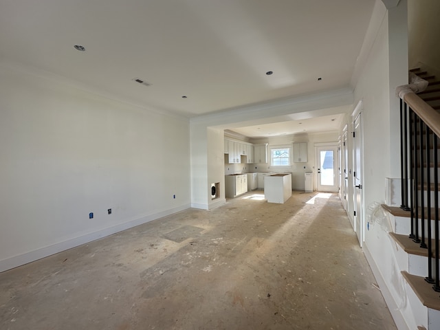 unfurnished living room with ornamental molding