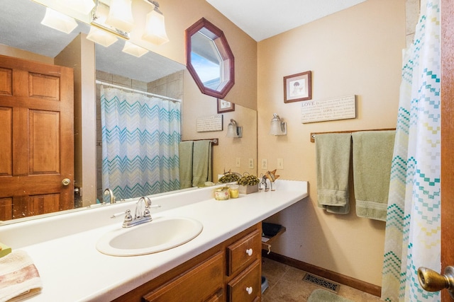 bathroom with tile patterned floors, vanity, and walk in shower