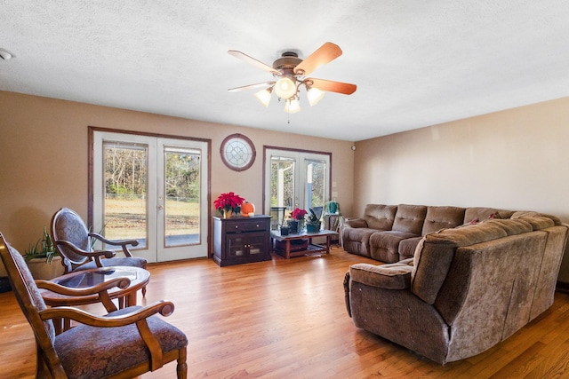 living room with hardwood / wood-style flooring, ceiling fan, a textured ceiling, and french doors