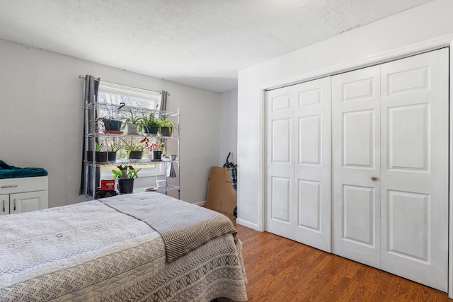 bedroom featuring hardwood / wood-style floors, a textured ceiling, and a closet