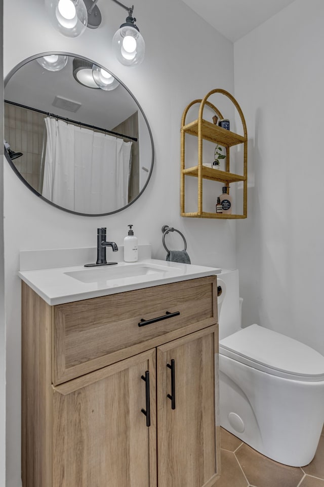 bathroom with toilet, a shower with curtain, vanity, and tile patterned floors