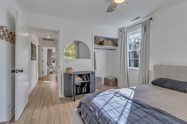 bedroom featuring light wood-type flooring, multiple windows, and ceiling fan