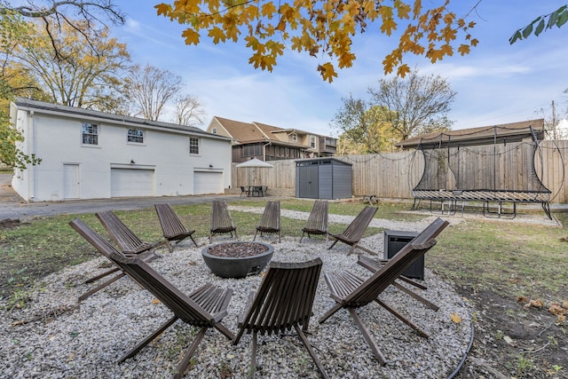 view of patio / terrace featuring a shed, a trampoline, and a fire pit