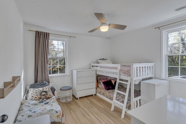 bedroom featuring light hardwood / wood-style flooring, multiple windows, and ceiling fan