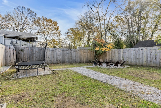 view of yard featuring a fire pit and a trampoline