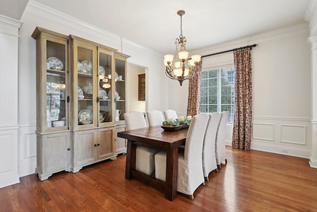 dining room featuring dark wood-type flooring, crown molding, and a notable chandelier