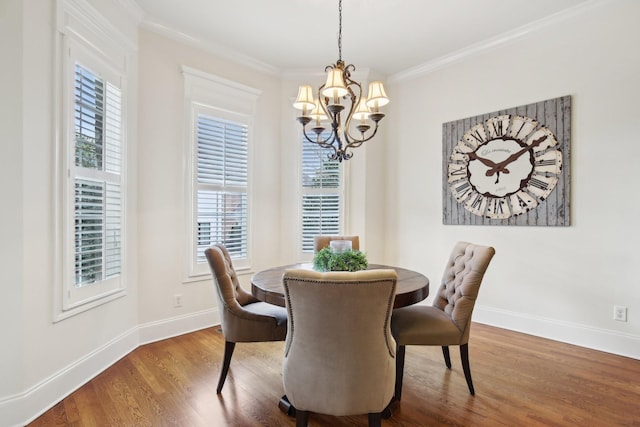 dining area featuring an inviting chandelier, crown molding, and wood-type flooring