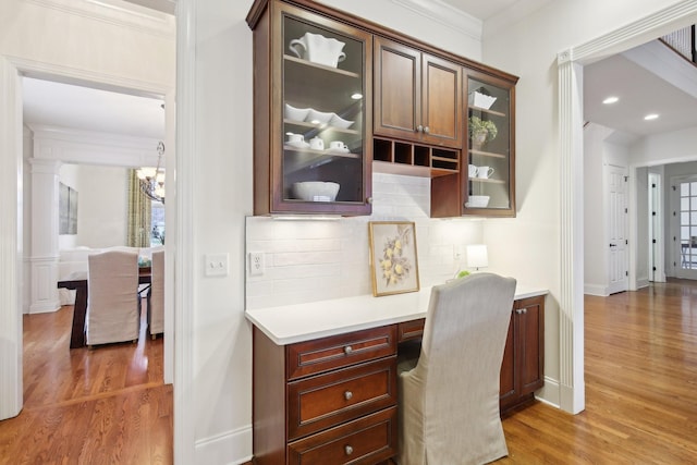 office space with hardwood / wood-style flooring, crown molding, and built in desk