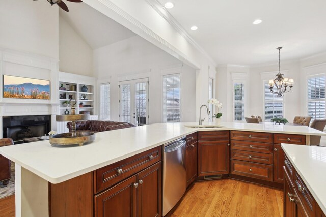 kitchen with sink, crown molding, hanging light fixtures, light hardwood / wood-style floors, and stainless steel dishwasher