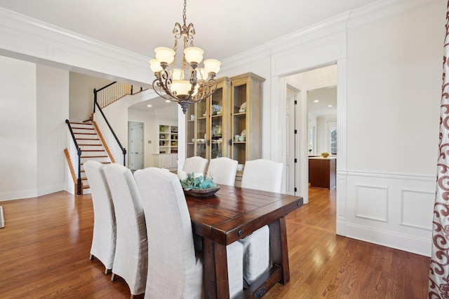 dining space with crown molding, dark hardwood / wood-style flooring, and a chandelier